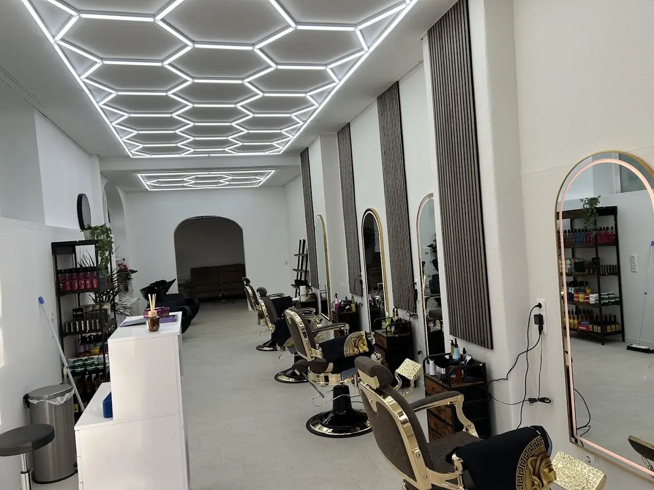 Salon von Bro's Barber Kiel mit goldenen Barber-Stühlen und moderner Wabenbeleuchtung